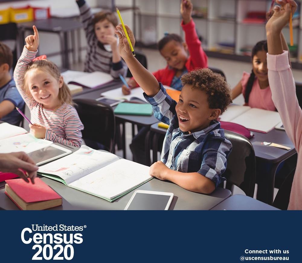 School children with hands raised for questions