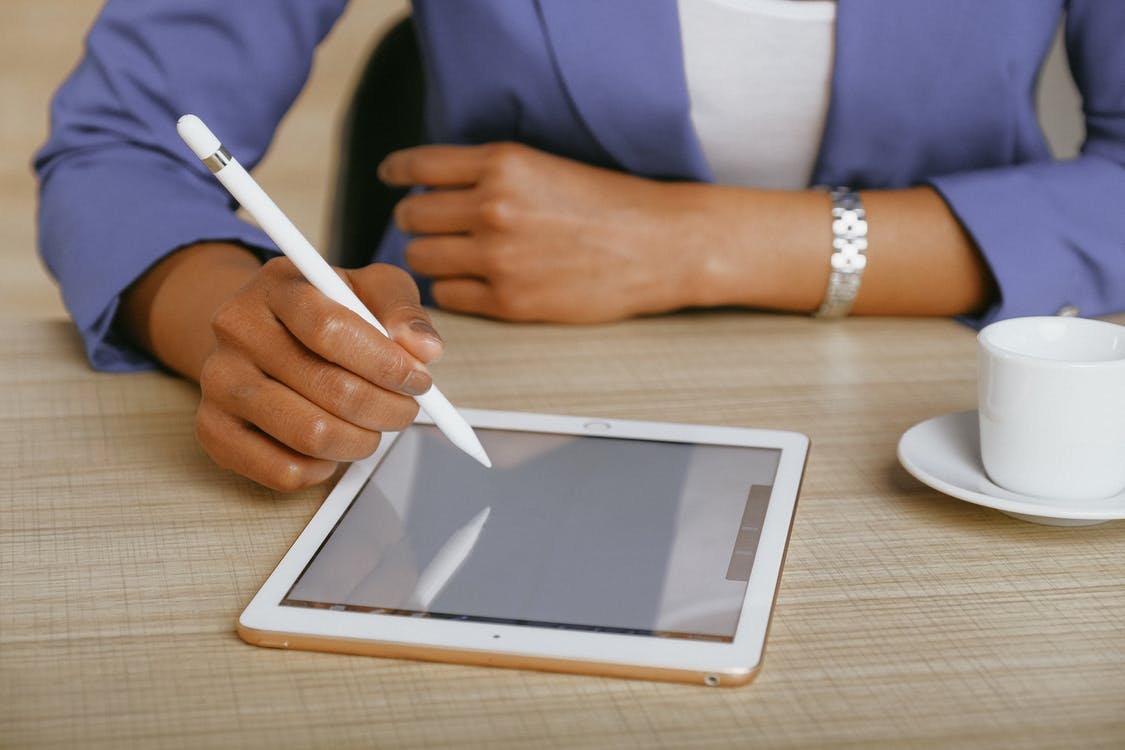 A person uses a pencil to take a survey on a tablet